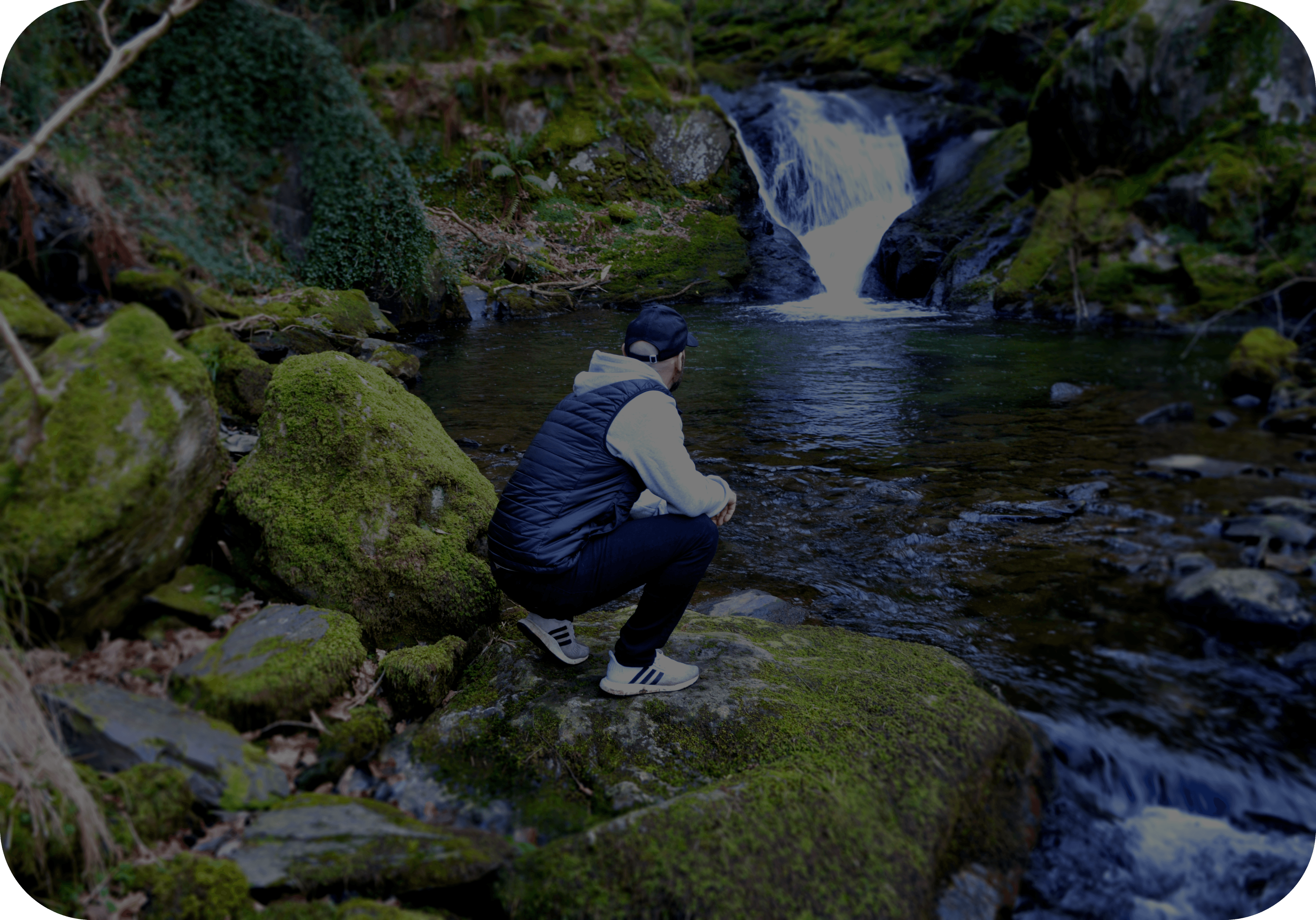 Man standing in front of a waterfall